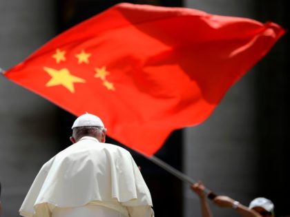 A worshipers waves the flag of China as Pope Francis leaves following the weekly general a