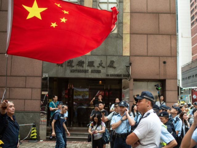 A pro-Beijing protester holds a Chinese flag in support of Tiananmen crackdown during a ma