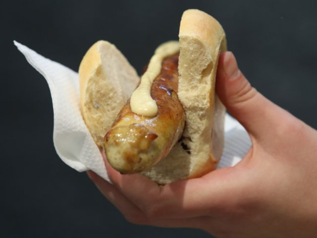 BERLIN, GERMANY - JANUARY 19: A visitor holds a Thuringian rostbratwurst pork sausage with