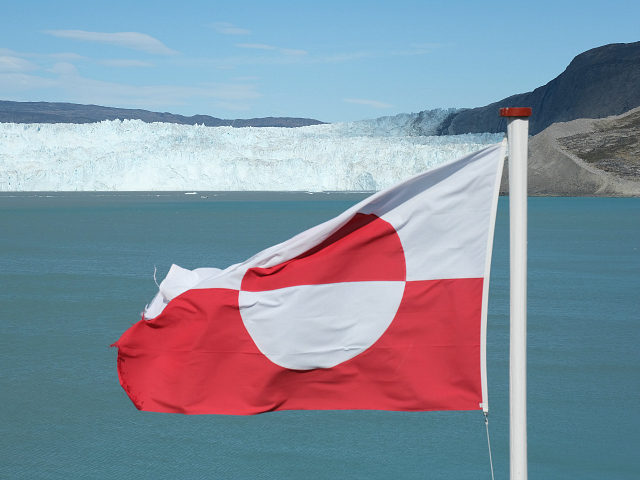 EQIP SERMIA, GREENLAND - JULY 31: A Greenlandic flag flies near the Eqip Sermia glacier, also called the Eqi Glacier, on July 31, 2019 at Eqip Sermia, Greenland. As the Earth's climate warms summers have become longer in the region, allowing fishermen a wider period to fish from boats on …