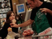NEW YORK - SEPTEMBER 17: A co-op shopper (R) bags his groceries while a fellow co-op member works the cash register at the Park Slope Food Coop on September 17, 2010 in the Brooklyn borough of New York City. The Park Slope Food Coop, where shoppers must work periodic shifts …