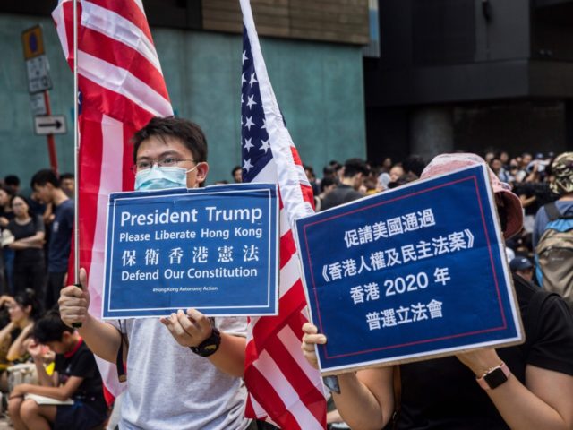 Protesters hold signs as they gather in Mong Kok during a general strike in Hong Kong on A