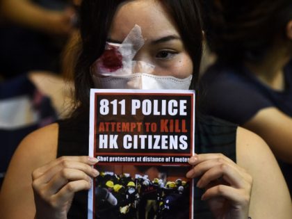An anti-extradition bill protester holds a sign against police brutality during a gathering at Chater House Garden in Hong Kong on August 16, 2019. - Hong Kong's pro-democracy movement faces a major test this weekend as it tries to muster another huge crowd following criticism over a recent violent airport …