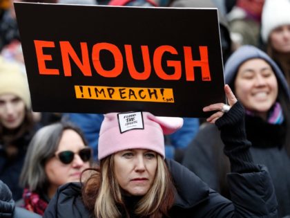 A woman holds a sign expressing her opinion about impeaching President Donald Trump at a rally organized by Women's March NYC at Foley Square in Lower Manhattan, Saturday, Jan. 19, 2019, in New York. (AP Photo/Kathy Willens)