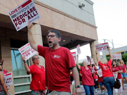 People with National Nurses United march in support of medicare for all, outside of the Knight Concert Hall at the Adrienne Arsht Center for the Performing Arts of Miami-Dade County, where a Democratic presidential debate is taking place, Wednesday, June 26, 2019, in Miami. (AP Photo/Lynne Sladky)