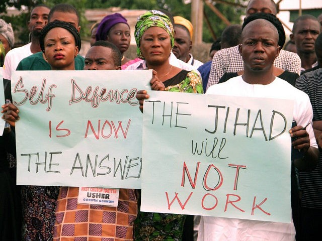 Church members carry placards reading "self defence is now the answer" "the jihad will not work", as they take part in a protest against the killing of people by suspected herdsmen in Makurdi, north-central Nigeria, on April 29, 2018. - On April 24, 2018, at least 18 people, including two …