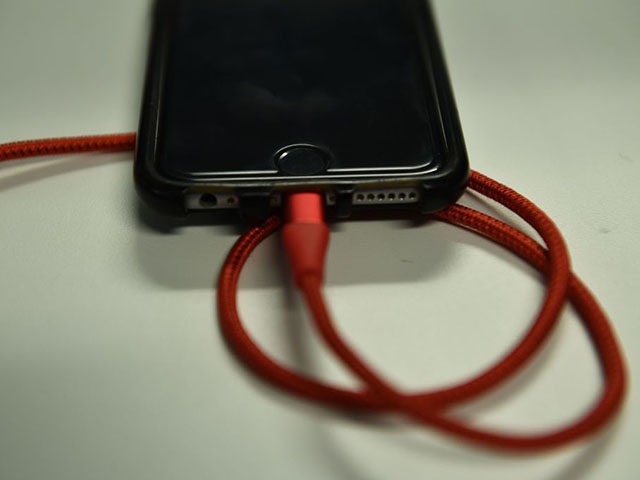 An iPhone 6S is plugged into a battery charger on March 18, 2019 in Washington,DC. (Photo