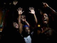 In this Aug. 17, 2014 file photo, people defy a curfew before smoke and tear gas was fired to disperse a crowd protesting the shooting of Michael Brown in Ferguson, Mo. The one year anniversary of the shooting of Brown, which sparked months of nationwide protests and launched the "Black …