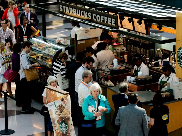 In this Thursday, May 30, 2013, file photo, customers line up at a Starbucks Coffee in New York. Starbucks wants a little extra change for that latte. The Seattle-based coffee company says it's hiking prices on average by 1 percent nationally starting on Tuesday, June 25, 2013, but it says …