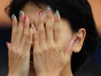 woman hiding behind hands