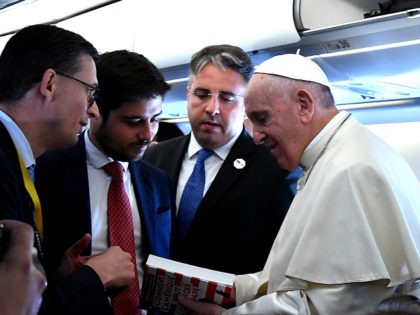 Pope Francis holds the book " Comment l'Amerique veut changer le Pape " ( How the America