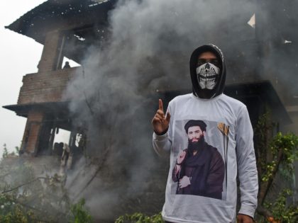 A Kashmiri protestor wears a shirt depicting a picture of a militant commander Zakir Musa as he stands in front of a damaged house following a gun battle between a top militant commander Zakir Musa of Ansar Ghazwat-ul-Hind group and Indian government forces at Dadsar village in Tral, south of …
