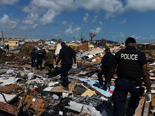 Members of the police join a recovery team looking in the debris in Marsh Harbour, Bahamas