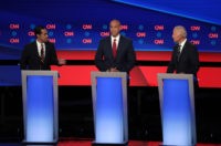 DETROIT, MICHIGAN - JULY 31: Democratic presidential candidate Julian Castro (L)) speaks Sen. Cory Booker (D-NJ) (C) and former Vice President Joe Biden listen during the Democratic Presidential Debate at the Fox Theatre July 31, 2019 in Detroit, Michigan. 20 Democratic presidential candidates were split into two groups of 10 …