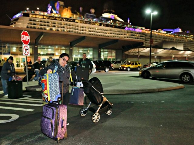 A passenger from the Royal Caribbean cruise ship, Anthem of the Seas, adjusts her luggage after disembarking from the ship upon arriving at Cape Liberty cruise port, Wednesday, Feb. 10, 2016, in Bayonne, N.J. Carrying 4,500 passengers and 1,600 crew members, the ship returned early from a seven-day cruise to …