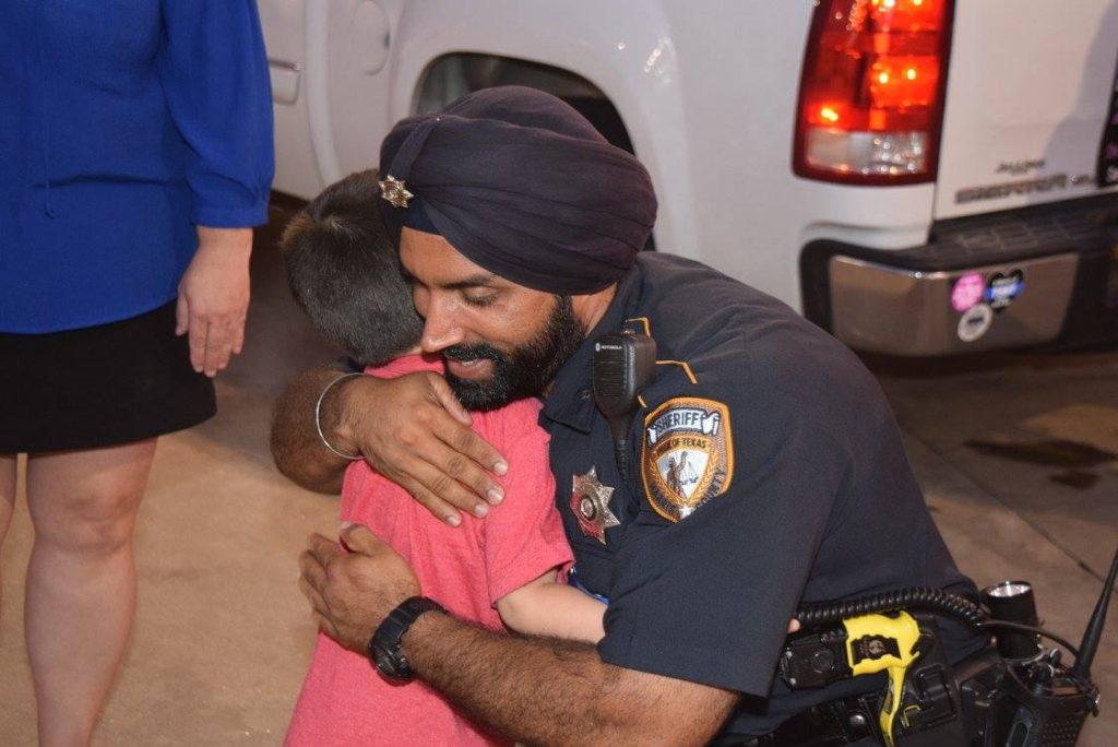 Deputy Sandeep Dhaliwal talks with a young boy at a memorial at the scene of the August 2015 rutal murder of fellow Deputy Darren Goforth. (Breitbart Texas Photo: Lana Shadwick)