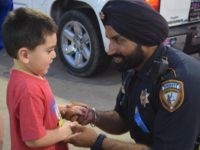 Deputy Sandeep Dhaliwal talks with a young boy at a memorial at the scene of the August 2015 rutal murder of fellow Deputy Darren Goforth. (Breitbart Texas Photo: Lana Shadwick)
