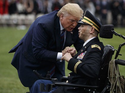 President Donald Trump greets Army Cpt. Luis Avila, who was severely wounded in Afghanistan, after Avila sang "God Bless America" during an Armed Forces welcome ceremony for the new chairman of the Joint Chiefs of Staff, Gen. Mark Milley, Monday, Sept. 30, 2019, at Joint Base Myer-Henderson Hall, Va. (AP …