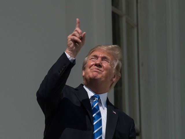 US President Donald Trump looks up at the partial solar eclipse from the balcony of the Wh