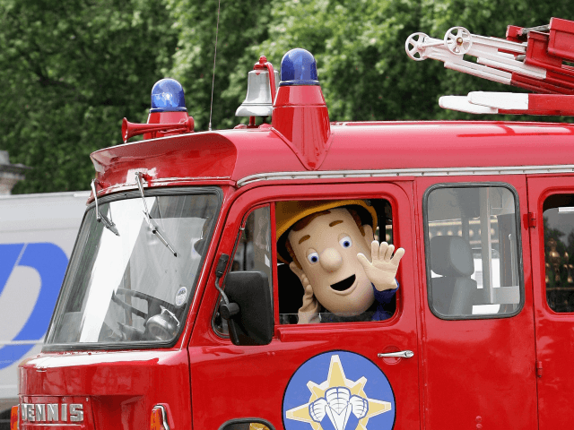 LONDON - JUNE 25: Fireman Sam arrives in his fire engine on the Forecourt of Buckingham Pa