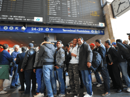 Tunisian would-be immigrants pose before boarding a train at Rome's Termini station t