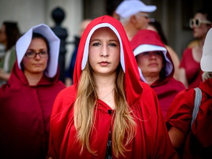 Handsmaid themed protesters stand outside Jackson Square in the French Quarter of New Orleans, Louisiana, on May 25, 2019, to protest the proposed Heartbeat Bill that will ban abortion after 6 weeks in that state scheduled for a vote on May 28. (Photo by Emily KASK / AFP) (Photo credit …