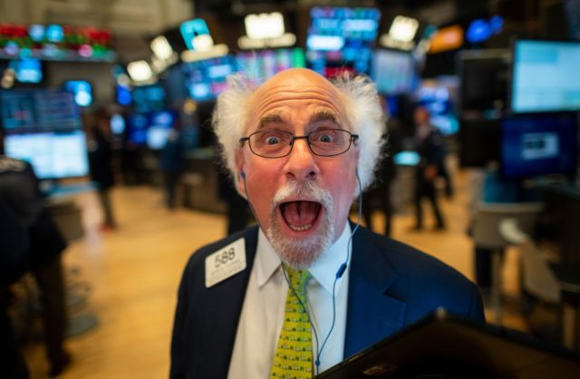 A traders jokes after the opening bell at the New York Stock Exchange (NYSE) on July 16, 2019 located at Wall Street in New York City. - Wall Street stocks edged down from records early Tuesday following mixed banking earnings and worrisome manufacturing data contrasted with strong US retail sales. …