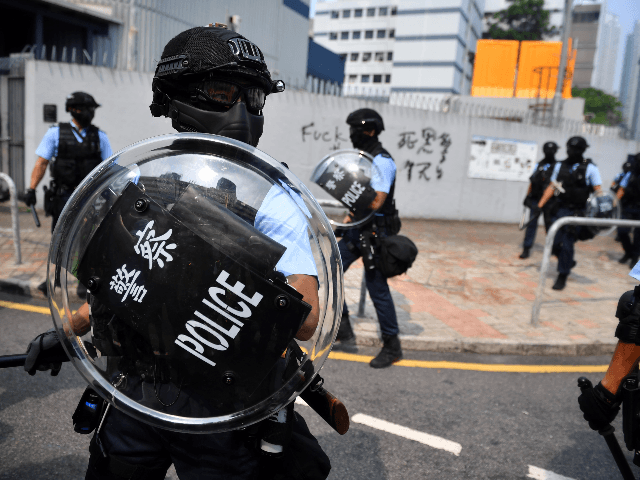 Riot police protect a police station from protesters at Kowloon Bay in Hong Kong on August