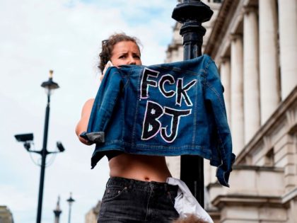 A protester holds up her jacket during a demonstration against the British government's move to suspend parliament in the final weeks before Brexit outside Downing Street in London on August 31, 2019. - Demonstrations, being dubbed "Stop The Coup" by organisers, were to be held across Britain on August 31 …