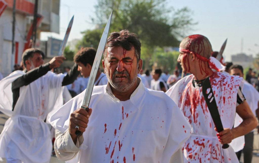 Iraqi men flagellate themselves with swords during the mourning procession on the tenth day of Muharram which marks the day of Ashura, in the Iraqi capital Baghdad on September 10, 2019. - Ashura is commemorated by Shiite Muslims worldwide and marks the climax of mourning rituals in the Islamic month of Muharram for the 7th century killing of Imam Hussein, the grandson of Prophet Mohammed, in the Battle of Karbala in 680 AD. (Photo by SABAH ARAR / AFP) (Photo credit should read SABAH ARAR/AFP/Getty Images)