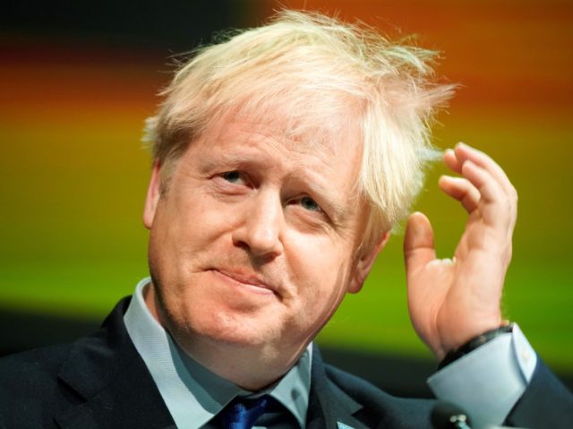 Britain's Prime Minister Boris Johnson gestures as he delivers his speech at the Conv