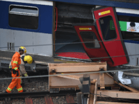Rescue workers investigate the scene of a passenger train that derailed during the rush hour outside Hung Hom railway station on the Kowloon side of Hong Kong on September 17, 2019. - A passenger train derailed during the morning rush hour in Hong Kong on September 17 leaving eight people …