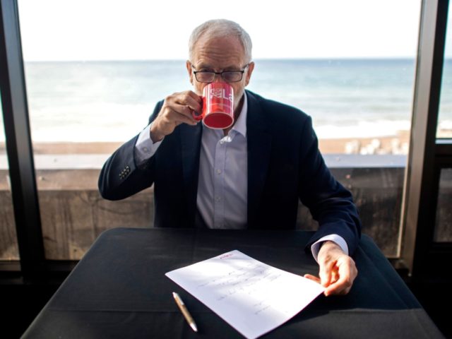 Britain's main opposition Labour Party Leader Jeremy Corbyn takes a drink as he poses