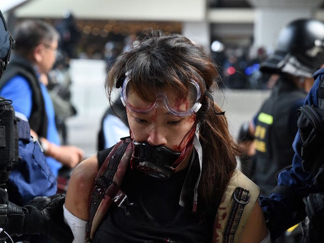 Hong Kong police detain a woman (C) near the central government offices after thousands took part in an unsanctioned march through Hong Kong on September 29, 2019, part a coordinated day of global protests aimed at casting a shadow over communist China's upcoming 70th birthday. - Hong Kong descended into a second day of clashes between pro-democracy protesters and riot police on September 29 as activists step up their nearly four months campaign ahead of the 70th anniversary of communist China's founding. (Photo by Mohd RASFAN / AFP) (Photo credit should read MOHD RASFAN/AFP/Getty Images)