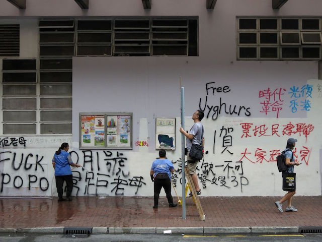Cleaners try to remove graffiti put up by protesters in Hong Kong on September 30, 2019, a day after the protest-wracked financial hub witnessed its fiercest political violence in weeks. - Ripped-up paving stones lay scattered around the graffiti-strewn streets of Hong Kong on September 30 after one of the most violent days in a summer of rage, as protesters ready for fresh clashes on the 70th anniversary of communist China's founding. (Photo by Richard A. Brooks / AFP) (Photo credit should read RICHARD A. BROOKS/AFP/Getty Images)
