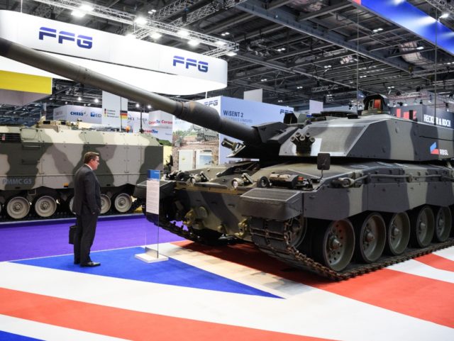 LONDON, ENGLAND - SEPTEMBER 11: A delegate studies a Challenger II tank on day two of the DSEI arms fair at ExCel on September 11, 2019 in London, England. The biennial Defence and Security Equipment International (DSEI) is the world's largest arms fair and is held in London's Docklands area. …