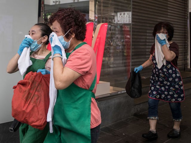 HONG KONG - SEPTEMBER 29: Women run covering their mouths after police fired tear gas to disperse pro-democracy protesters ahead of a march on September 29, 2019 in Hong Kong, China. Pro-democracy demonstrations have entered its fourth month as Hong Kong braces for the 70th anniversary of the founding of the People's Republic of China with a series of pro and anti-Beijing protests scheduled towards October 1. Anti-government protesters have continued its call for Chief Executive Carrie Lam to meet their remaining demands, including an independent inquiry into police brutality, the retraction of the word ‚Äúriot‚Äù to describe the rallies, and genuine universal suffrage. (Photo by Chris McGrath/Getty Images)