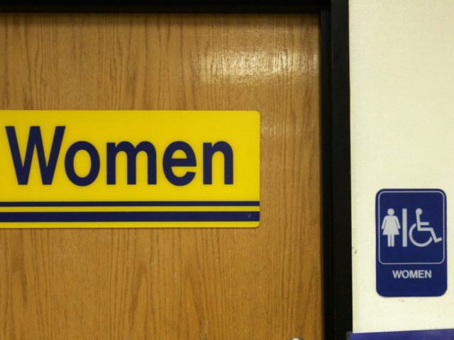A sign informing voters of where to cast their ballots hangs next to the Women's Restroom