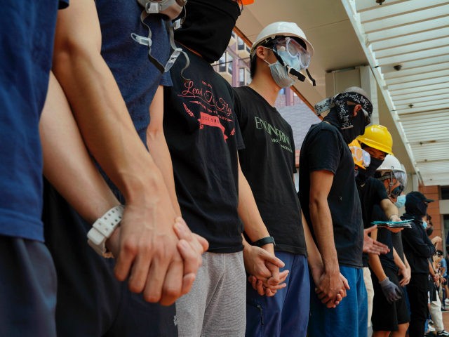 Students from Hong Kong University chains their hands outside schools in Hong Kong, Monday