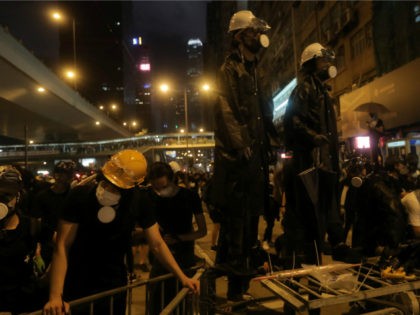 Protesters stand on improvised barricades after a march against a controversial extraditio