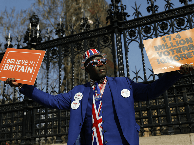 Pro-Brexit activist Joseph Afrane holds placards as he demonstrates outside the Houses of