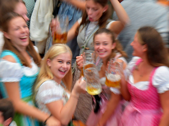 Young women in traditional Bavarian dress raise their beer glasses in a beer tent at the Oktoberfest beer festival in Munich, southern Germany, on September 22, 2019. - The world's biggest beer festival Oktoberfest will be running until October 6, 2019. (Photo by Tobias SCHWARZ / AFP) (Photo credit should …