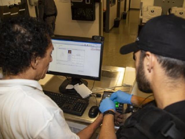 An ICE officer processes a suspected human rights violator during Operation Safe Haven V.