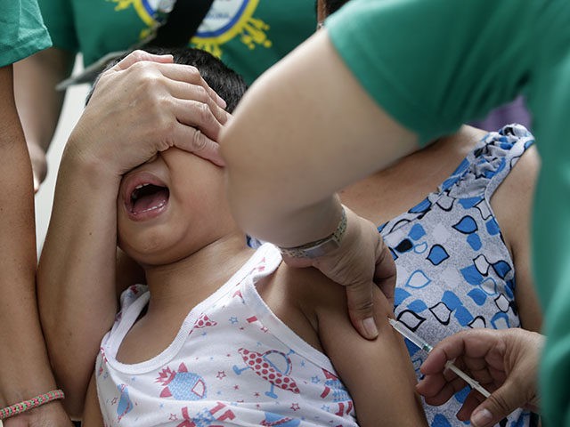 A local health worker administers a vaccine at a local health center at the financial district of Makati, east of Manila, Philippines, Friday, Sept. 12, 2014. The World Health Organization and the British government are working with the Philippine Department of Health, UNICEF and a host of other partners to …