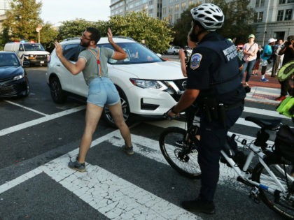 A climate change protester blocks traffic during a protest to shut down D.C. on September