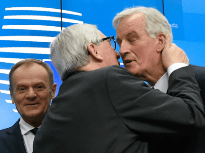 President of the European Commission Jean-Claude Juncker (C) kisses EU chief Brexit negotiator Michel Barnier (R) next to European Council President Donald Tusk (L) at the end of a press conference following a special meeting of the European Council to endorse the draft Brexit withdrawal agreement and to approve the …