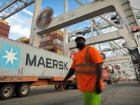 In this Thursday, July, 5, 2018 photo, a longshoreman prepares to direct the next shipping container to be picked up by a ship to shore crane at the Port of Savannah in Savannah, Ga. The United States and China launched what Beijing called the "biggest trade war in economic history" …