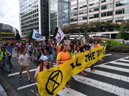 Environmental activists block an intersection as they gather to protest to shut down the c