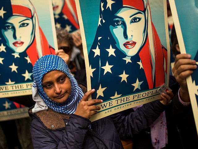 People carry posters during a rally against President Donald Trump's executive order banning travel from seven Muslim-majority nations, in New York's Times Square, Sunday, Feb. 19, 2017. (AP Photo/Andres Kudacki)