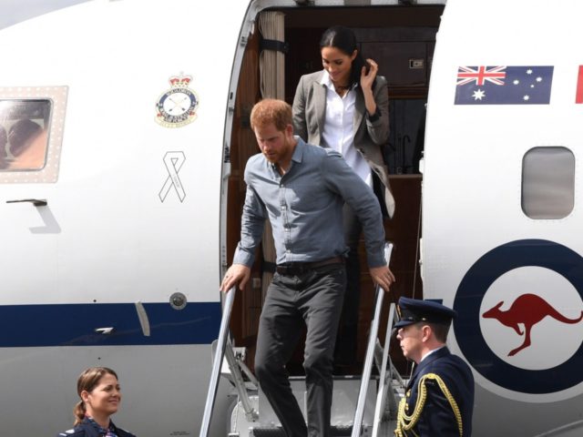 Britain's Prince Harry and his wife Meghan, the Duchess of Sussex disembark from their plane following their arrival in Dubbo on October 17, 2018. - Prince Harry and his expectant wife Meghan visited a drought-stricken region of Australia on October 17, bringing a rare and welcome rainstorm with them. (Photo …